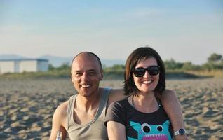 heureux jeune couple s'amuser sur la plage photo