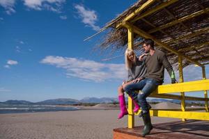 jeune couple buvant de la bière ensemble à la plage photo