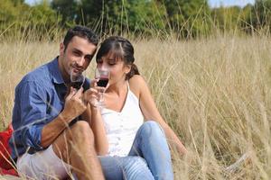 couple heureux profitant d'un pique-nique à la campagne dans l'herbe haute photo