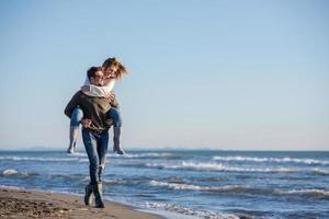 couple s'amusant à la plage en automne photo