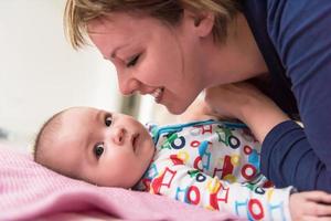 jeune mère embrassant son mignon petit bébé photo