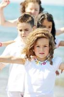 groupe d'enfants heureux jouant sur la plage photo