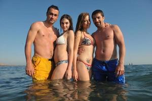 groupe de personnes heureuses s'amuser et courir sur la plage photo