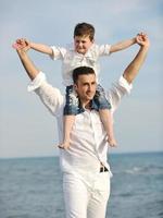 heureux père et fils s'amusent et profitent du temps sur la plage photo