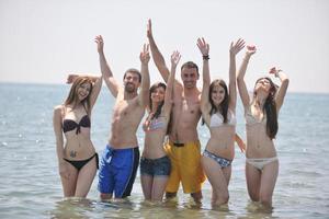 groupe de personnes heureuses s'amuser et courir sur la plage photo