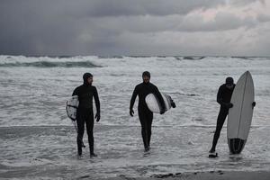 surfeurs arctiques passant par la plage après avoir surfé photo