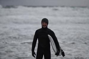 surfeur arctique passant par la plage après avoir surfé photo