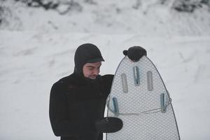 portrait de surfeur arctique tenant une planche après avoir surfé en mer norvégienne photo