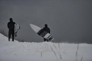 surfeurs arctiques courant sur la plage après avoir surfé photo