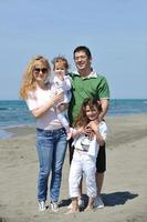 jeune famille heureuse s'amuser sur la plage photo