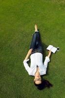 jeune femme lisant un livre dans le parc photo