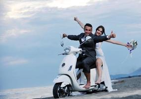 couple juste marié sur la plage ride scooter blanc photo