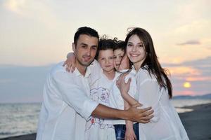 jeune famille heureuse s'amuser sur la plage photo