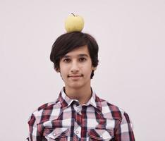 portrait d'un jeune adolescent avec une pomme sur la tête photo