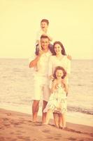 jeune famille heureuse s'amuser sur la plage photo