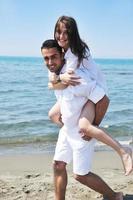 heureux jeune couple s'amuser sur la plage photo