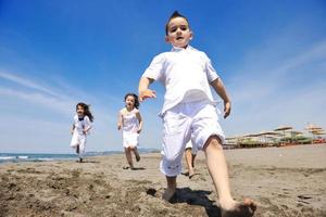 groupe d'enfants heureux jouant sur la plage photo