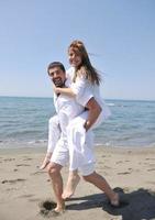 heureux jeune couple s'amuser sur la plage photo