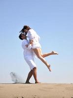 heureux jeune couple s'amuser sur la plage photo