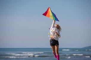 jeune femme avec cerf-volant à la plage le jour de l'automne photo