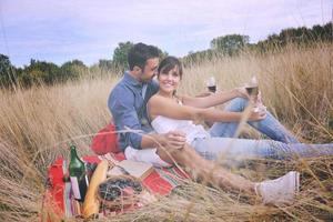 couple heureux profitant d'un pique-nique à la campagne dans l'herbe haute photo