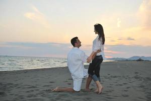 heureux jeune couple s'amuser sur la plage photo