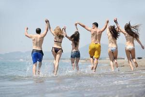 groupe de jeunes heureux s'amuser sur la plage photo