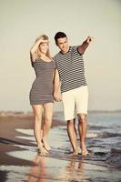 un jeune couple heureux passe un moment romantique sur la plage photo