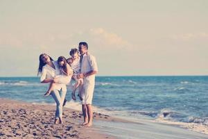 jeune famille heureuse s'amuser sur la plage photo