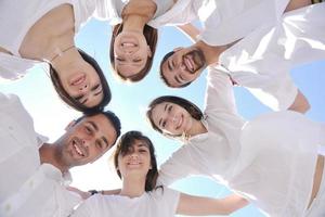 groupe de jeunes heureux en cercle à la plage photo