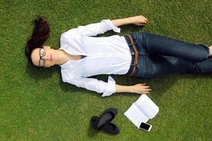 jeune femme lisant un livre dans le parc photo