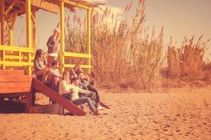 groupe d'amis s'amusant le jour de l'automne à la plage photo