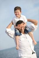 heureux père et fils s'amusent et profitent du temps sur la plage photo