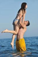 un jeune couple heureux passe un moment romantique sur la plage photo