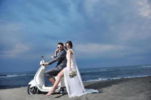 couple juste marié sur la plage ride scooter blanc photo