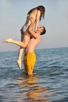 heureux jeune couple s'amuser sur la plage photo