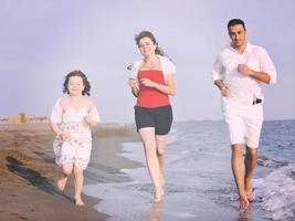 jeune famille heureuse s'amuser sur la plage photo