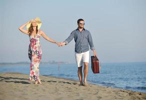 couple sur la plage avec sac de voyage photo