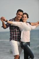 heureux jeune couple s'amuser sur la plage photo