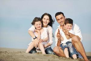 jeune famille heureuse s'amuser sur la plage photo