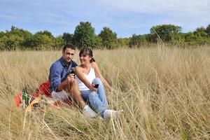 couple heureux profitant d'un pique-nique à la campagne dans l'herbe haute photo