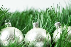 boules de sapin de noël en argent se trouvant entre une branche d'arbre de noël. symbole de vacances heureuses et paisibles. photo