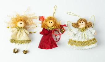 anges en lambeaux à accrocher au sapin de noël. décorations de noël en tissu faites à la main se trouvant sur un fond blanc. photo