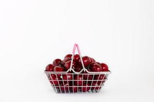 cerises douces mûres dans un petit panier isolé sur fond blanc avec espace de copie. photo