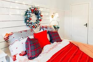 chambre intérieure classique avec sapin de noël et décorations rouges blanches traditionnelles. chambre d'appartement de design d'intérieur de style classique blanc propre moderne. réveillon de noël à la maison. conception de maison minimaliste. photo