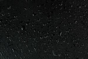 gouttes d'eau sur fond macro de surface en caoutchouc noir plat photo