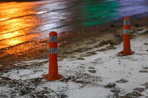 cônes de signalisation à la ville de nuit d'hiver avec de la neige et des empreintes de pas photo