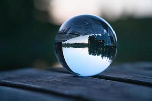 boule de verre sur une jetée en bois sur un lac suédois à l'heure du soir. nature scandinavie photo