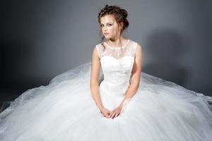 incroyable robe de mariée mariée assise sur le sol. tourné en studio photo