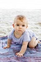 petite fille jouant avec du sable à la plage. développement sensoriel pour les enfants à l'extérieur. photo
